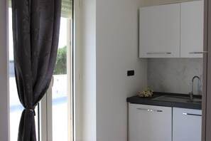 Appartement, 1 slaapkamer | Privékeuken | Een koelkast, een oven, een kookplaat, kookgerei, borden en bestek