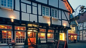 A traditional half-timbered building with a sign for 'The Olde Coach Inn' and a 'Hotel' sign. - Zur alten Krone (Hattingen)