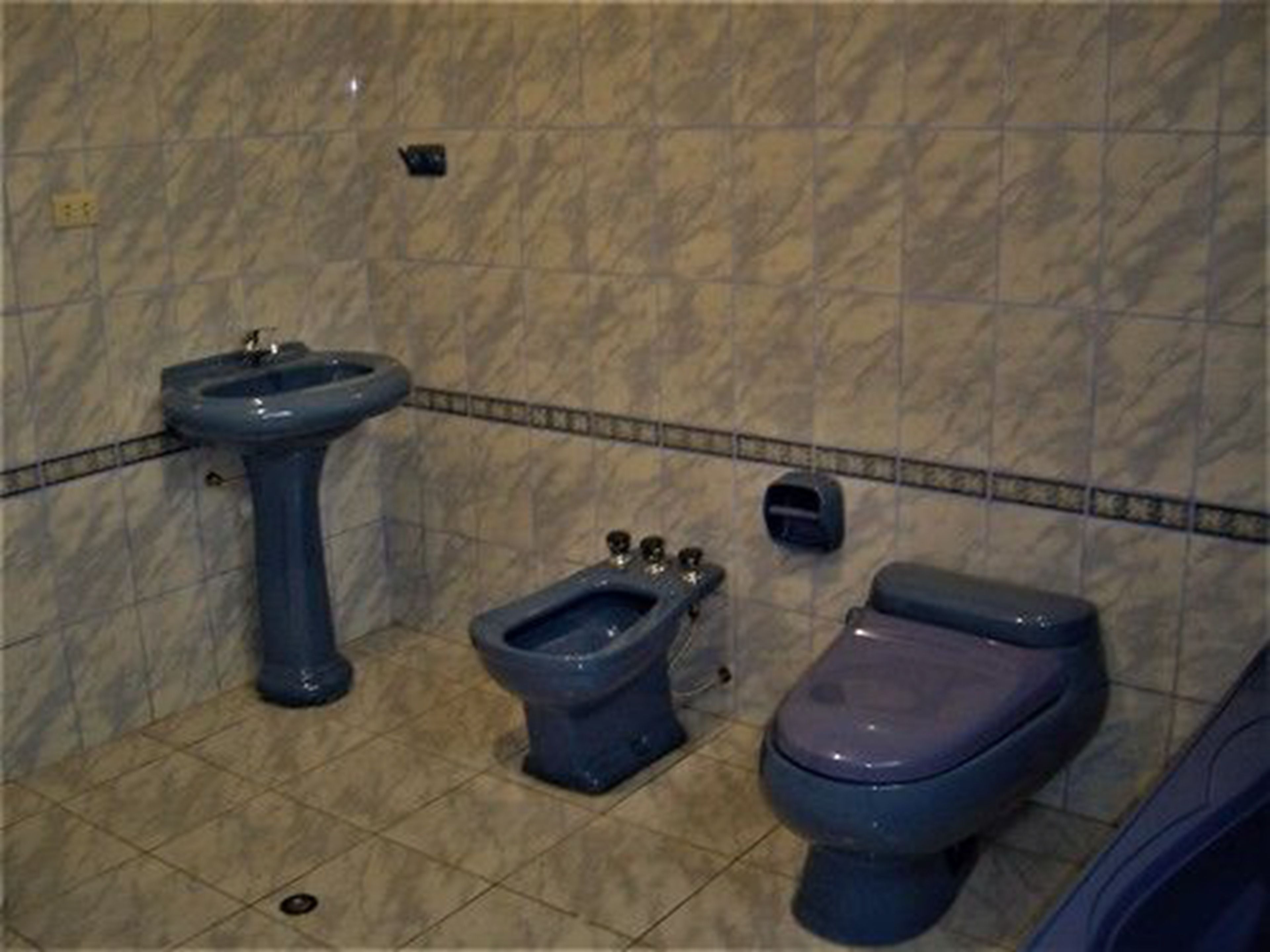 A bathroom with a pedestal sink, a bidet, and a toilet.
