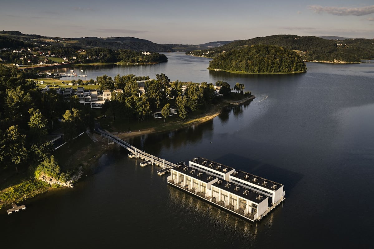 A floating hotel with multiple decks, a dock, and a bridge connecting to the mainland.