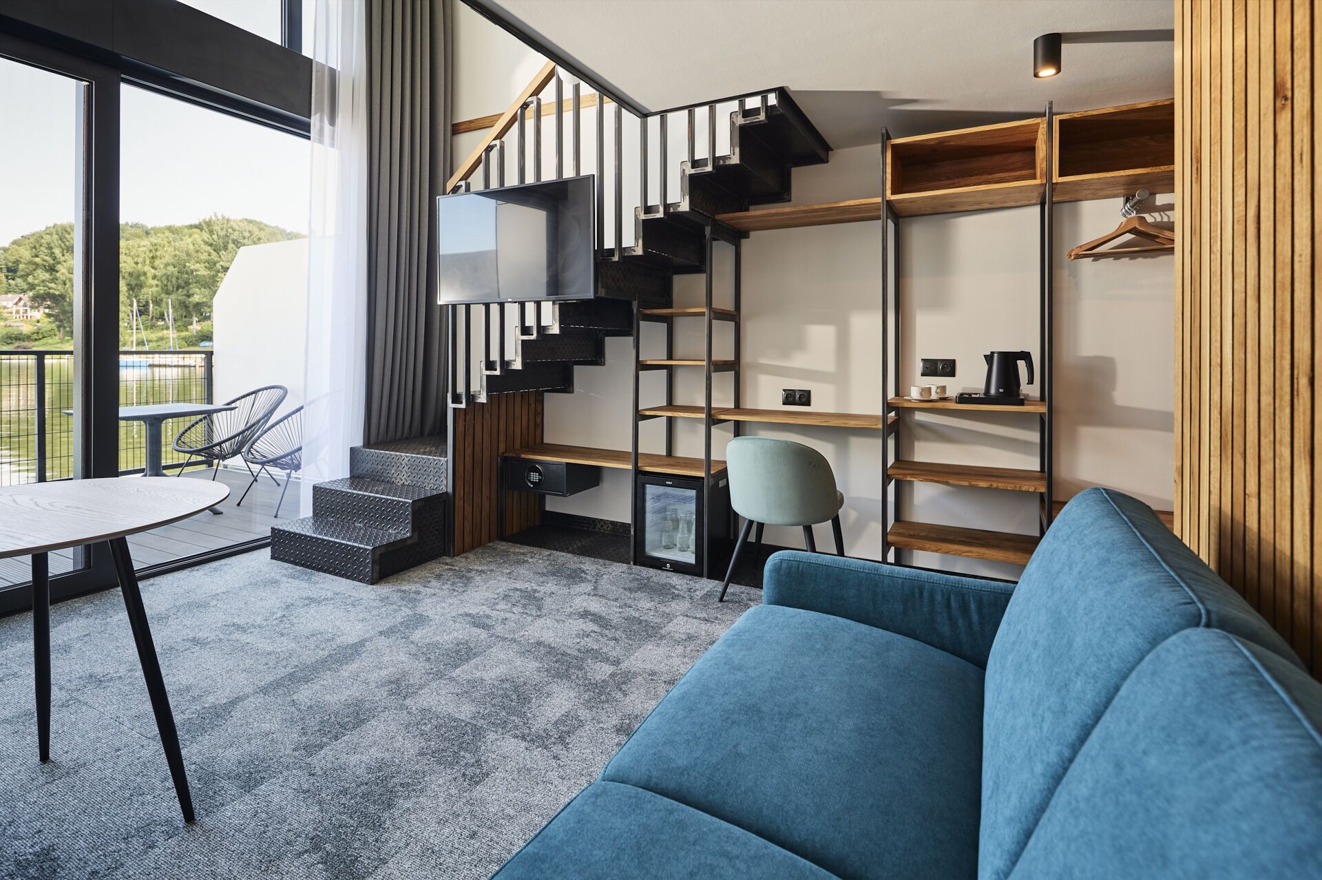A modern interior with a staircase, a sofa, a table, and a chair.