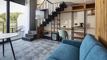 A modern interior with a staircase, a sofa, a table, and a chair.