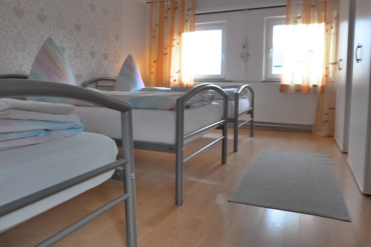 Un dormitorio con dos literas, un radiador y una ventana con cortinas.
