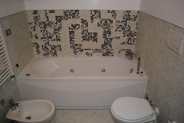 A bathroom with a large bathtub, a toilet, and a bidet. - B&B San Firmino (Venice)