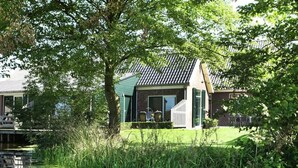 A house with a sloped roof, a front porch, and a small deck. - Rijnhoeve (Koudekerk aan den Rijn)
