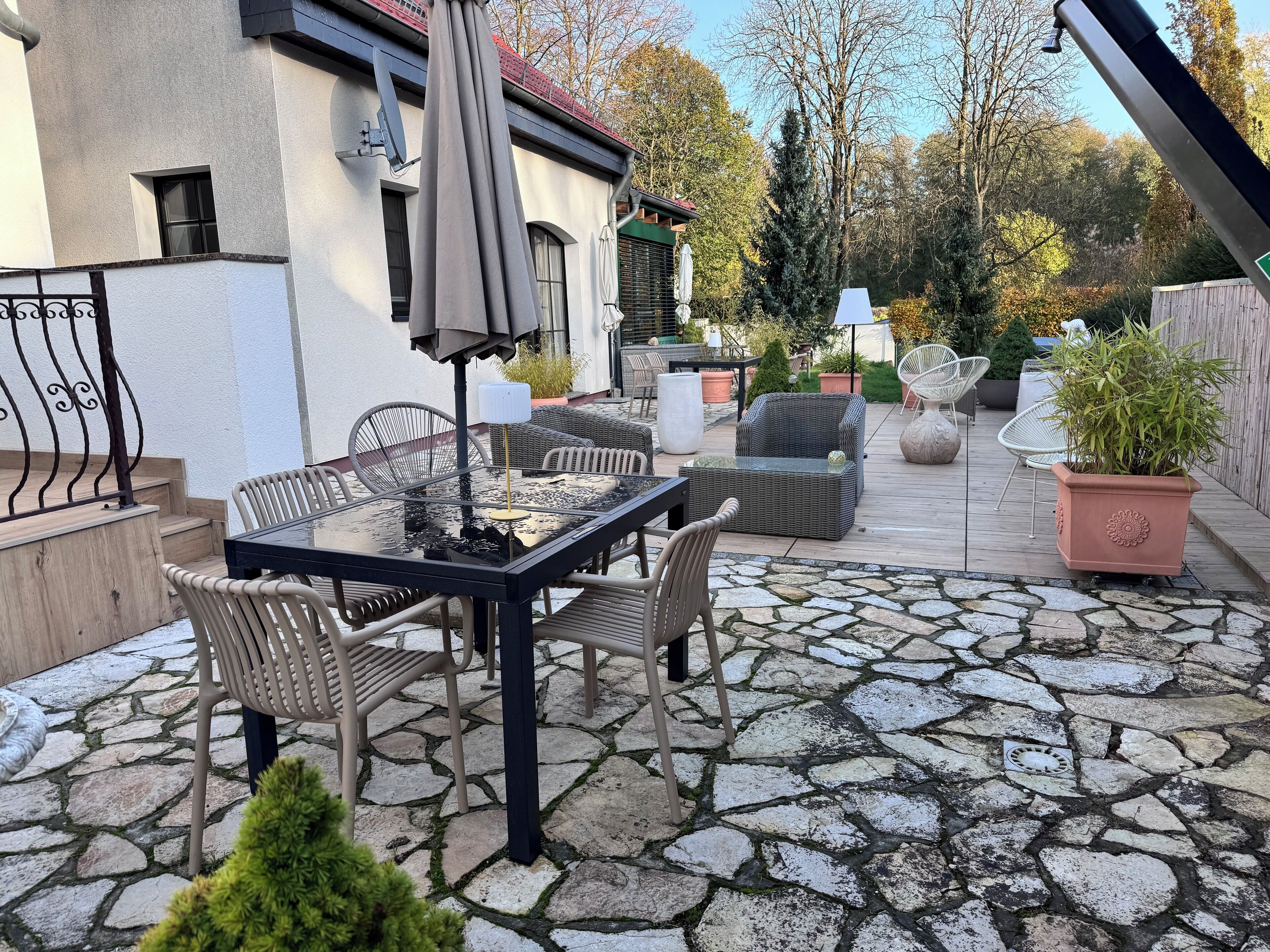 A patio with stone flooring, outdoor furniture, and a potted plant.