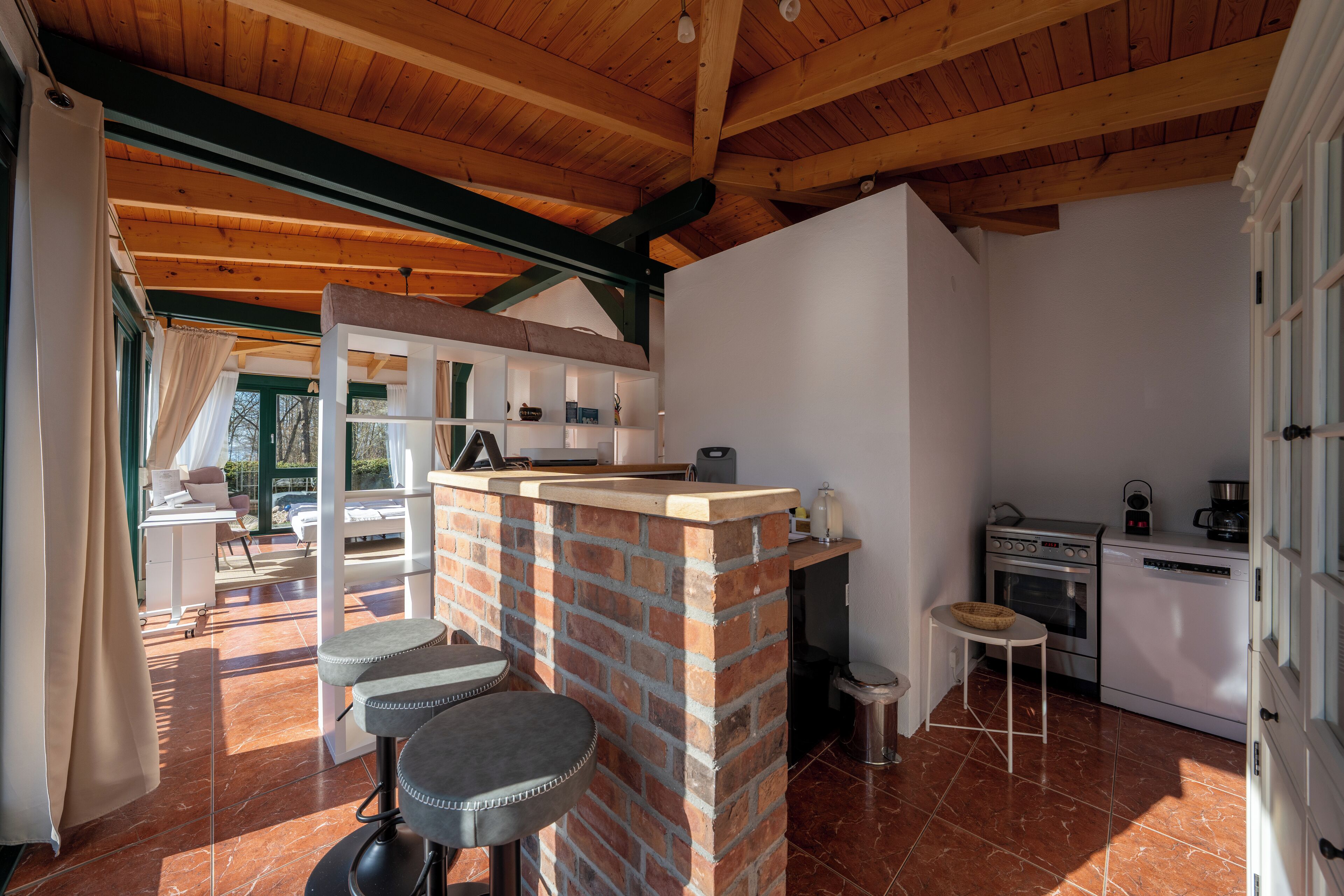 A kitchen with a brick island, a dining area with a table and chairs, and a view of the outdoors.