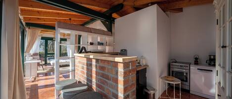 A kitchen with a brick island, a dining area with a table and chairs, and a view of the outdoors.