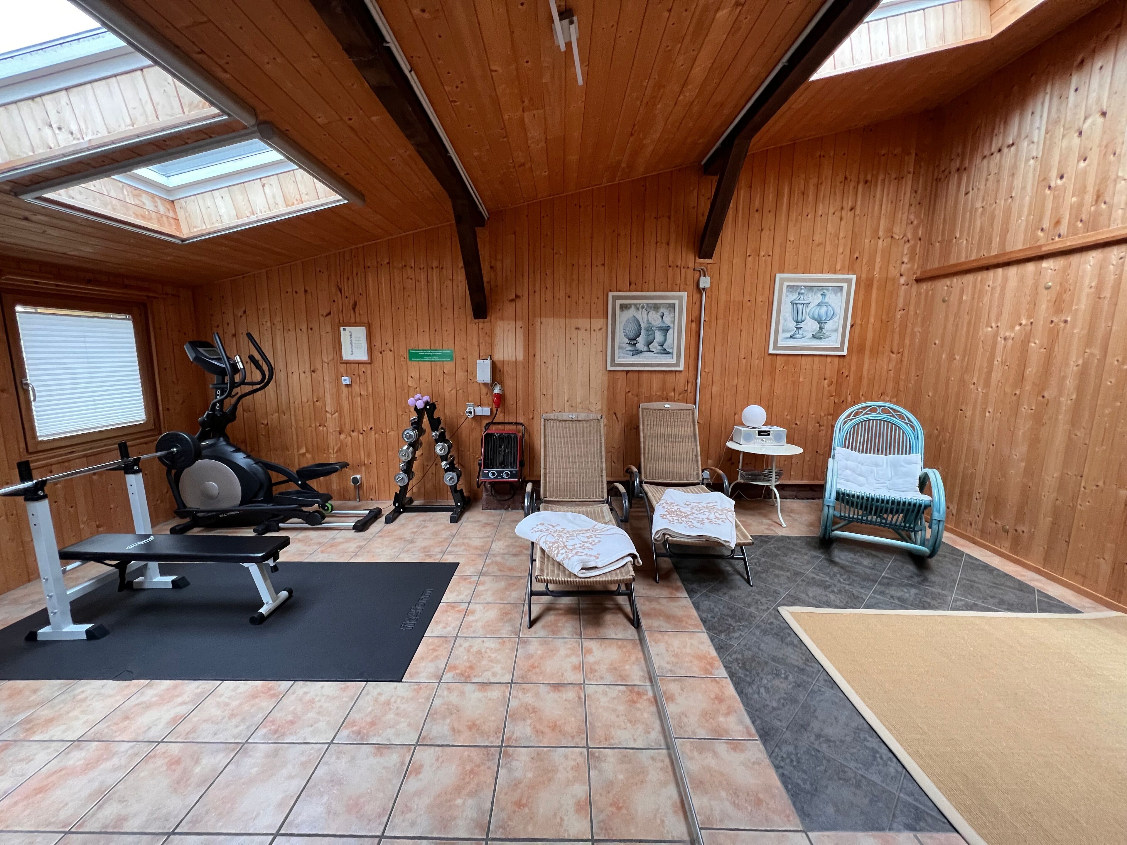 A gym with exercise equipment, a massage table, and a small table with a radio.