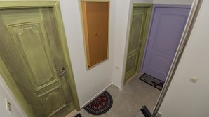 A hallway with green and purple doors, a small wooden door, and a red and black doormat. - Tequila apartments & rooms - Adults Only (Zadar)