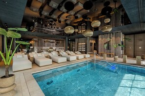 Una piscina cubierta, una piscina al aire libre, sombrillas, tumbonas