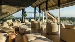 Un interior espacioso y moderno con ventanas amplias, techo de madera y mobiliario contemporáneo.