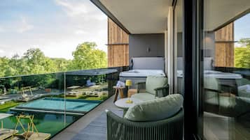 A modern balcony with a glass enclosure, a pool, and outdoor furniture.