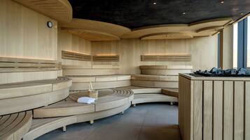 Una sauna moderna con bancos de madera curvada y una zona de estar central.