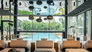 Un área de estar moderna con vista a la piscina, con sofás y detalles decorativos.