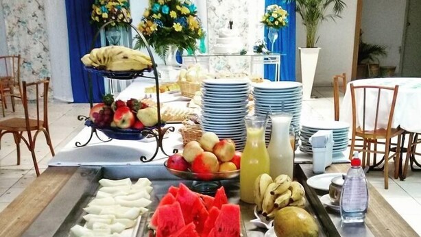Una mesa de buffet con distintos tipos de comida, como carnes cortadas, frutas y bebidas.