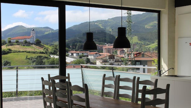 A dining area with a view of a lake and mountains. - Albergue Abaraxka - Hostel (Azkoitia)