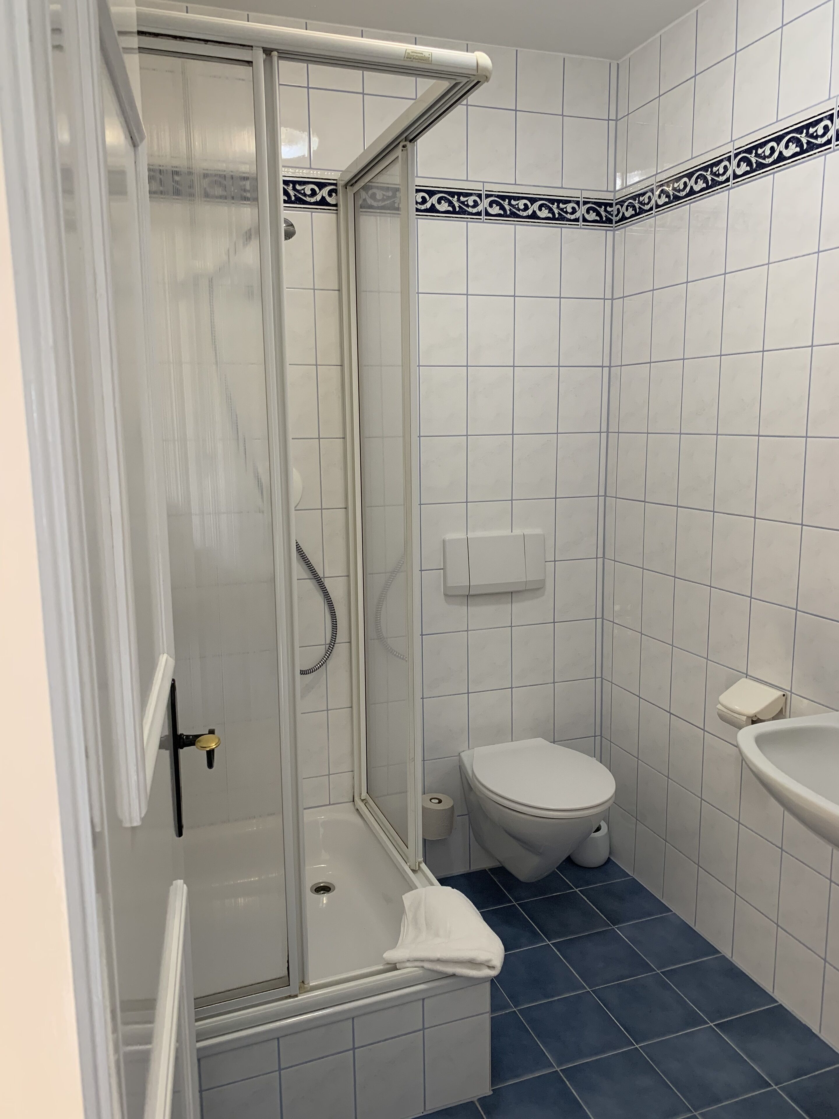 Ein Badezimmer mit Dusche, Toilette und Waschbecken.