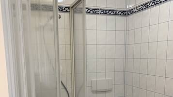 Ein Badezimmer mit Dusche, Toilette und Waschbecken.