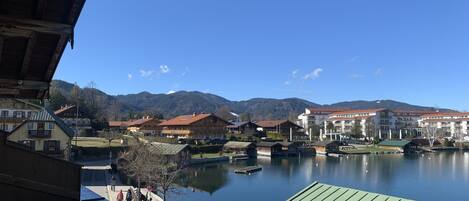 A lakeside view with traditional wooden buildings, a dock, and a clear blue sky.