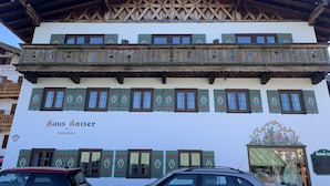 Un edificio tradicional con un balcón de madera y varias ventanas, identificado como "Haus Kaiser".