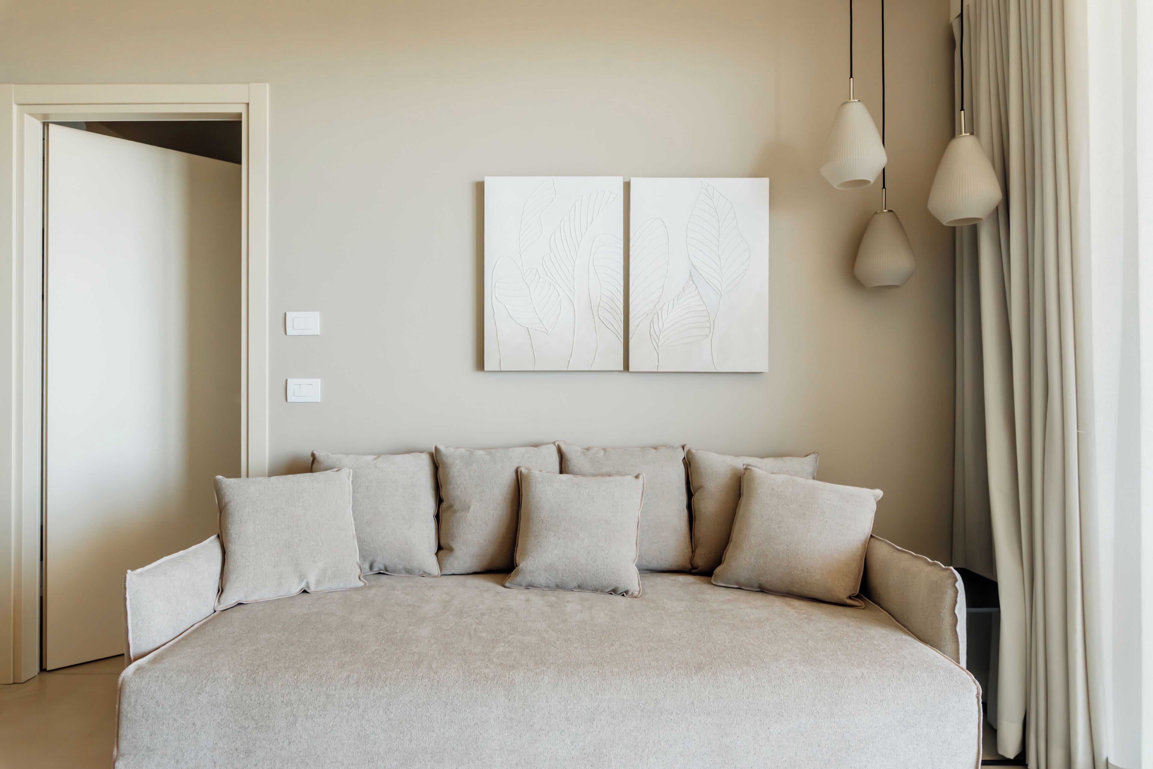 Un dormitorio con una cama grande, una puerta y una lámpara fijada a la pared.
