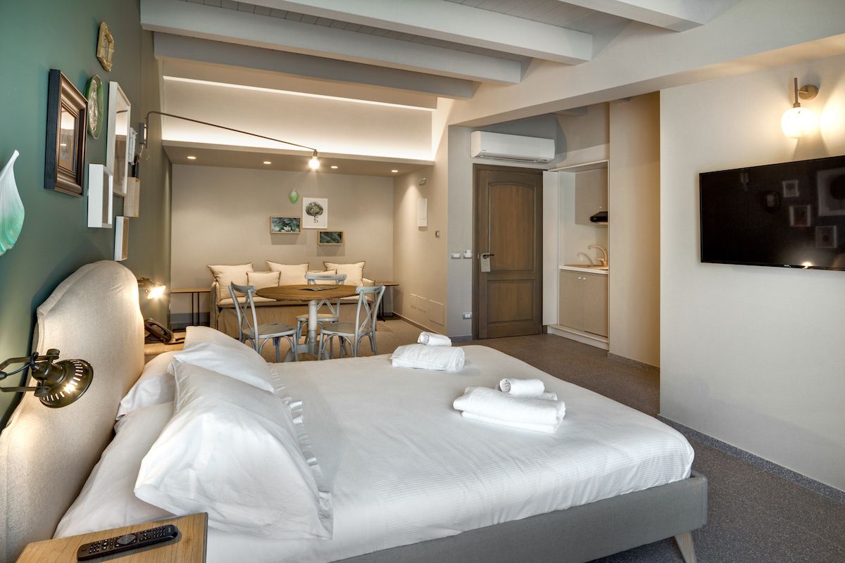 Una habitación de hotel con una cama grande, un escritorio y un comedor.