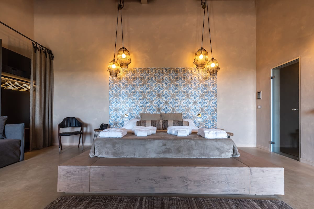 Un dormitorio moderno con una cama grande, una silla y un papel tapiz estampado.