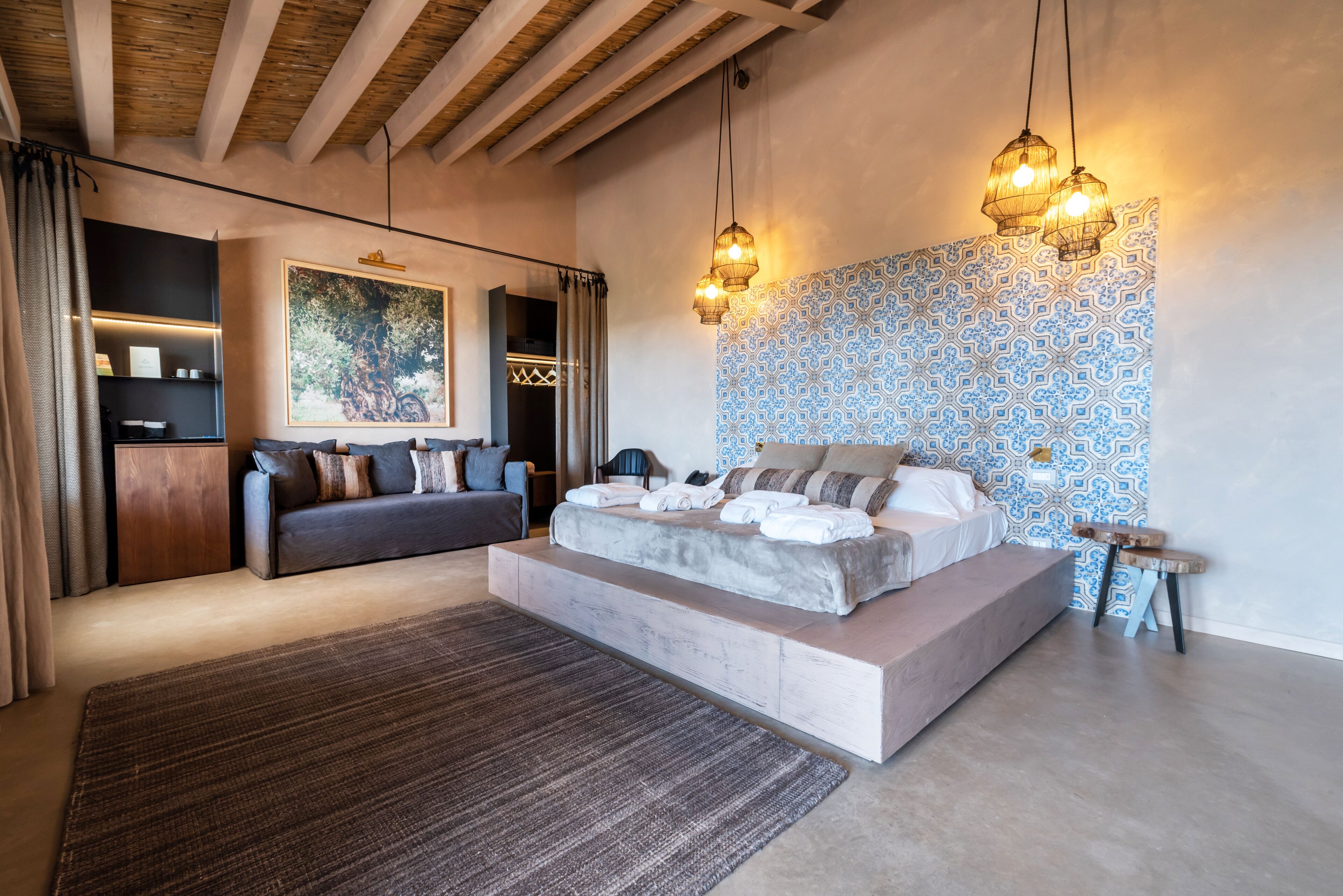 Un dormitorio moderno con una cama grande, un sofá y un techo de madera.