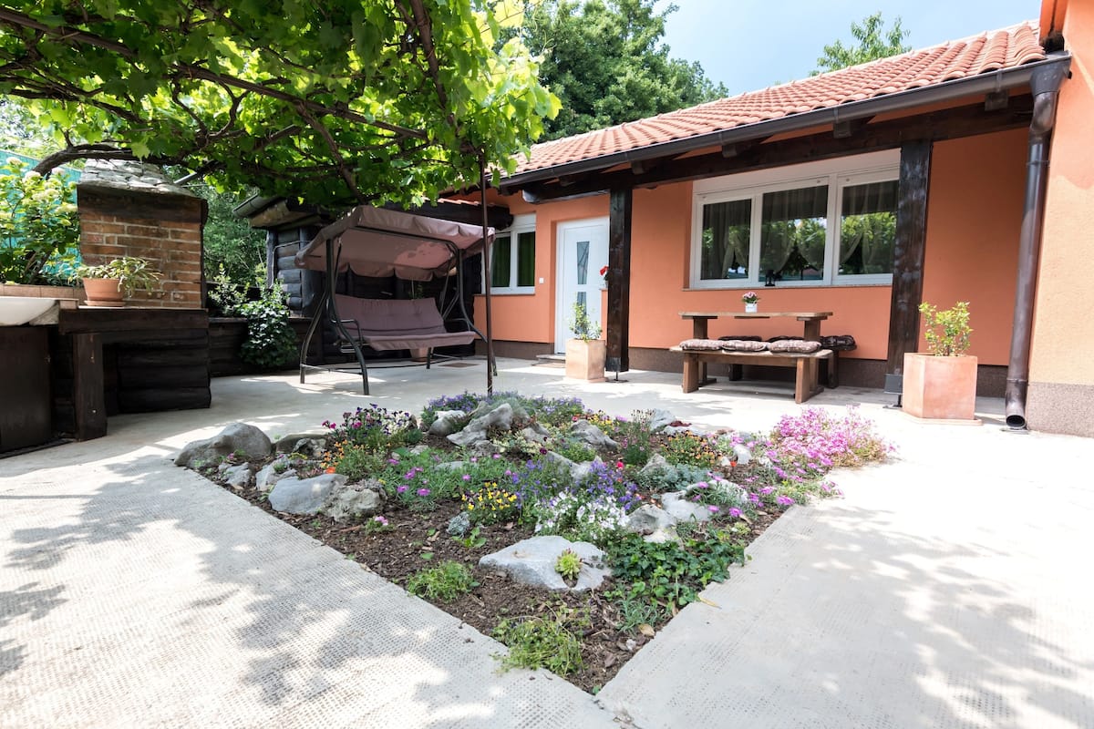 Un espace patio agrémenté d’un foyer en pierre, d’une table en bois et d’un coin salon abrité.