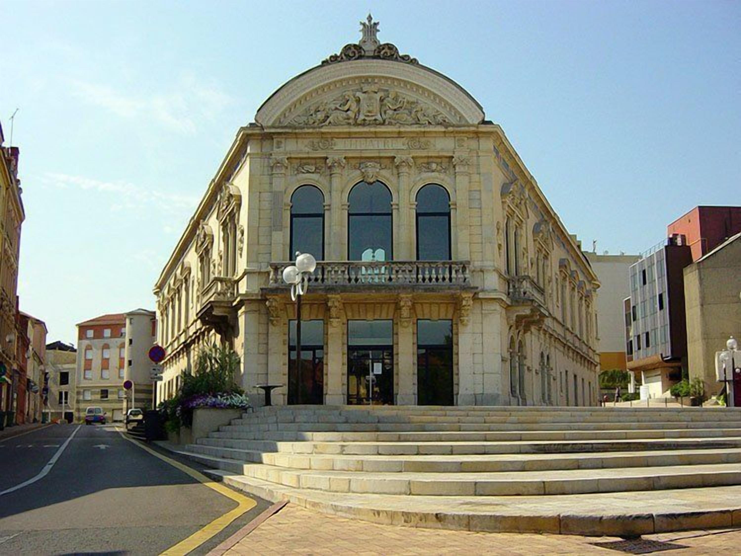 Un edificio histórico con una entrada imponente, grandes ventanales y una cúpula.