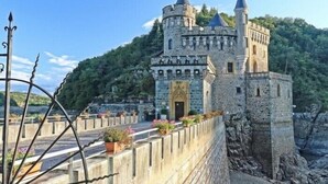 Un castillo con fachada de piedra, varias torres y una entrada.
