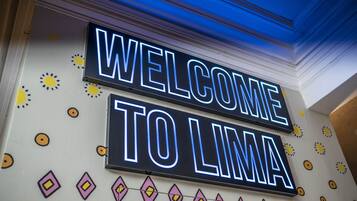 A neon sign with the words "WELCOME TO LIMA" on a wall.