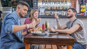 A group of people dining at a restaurant with a visible menu and a bar area in the background. - Pariwana Hostel Lima - Adults only (Lima)