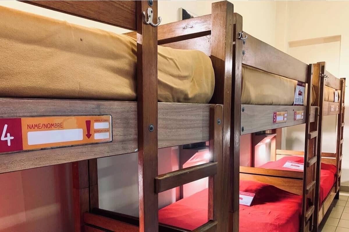 Bunk beds with individual name tags and a red bedspread.