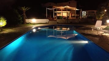 Una piscina al aire libre de temporada, sombrillas