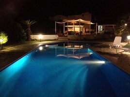 Una piscina al aire libre de temporada, sombrillas, tumbonas