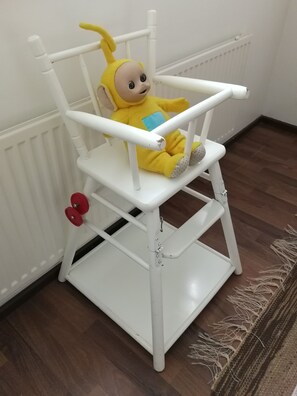 A white baby rocker with a yellow toy figure on it. - Scandinavian Sun Apartments (Kotka)