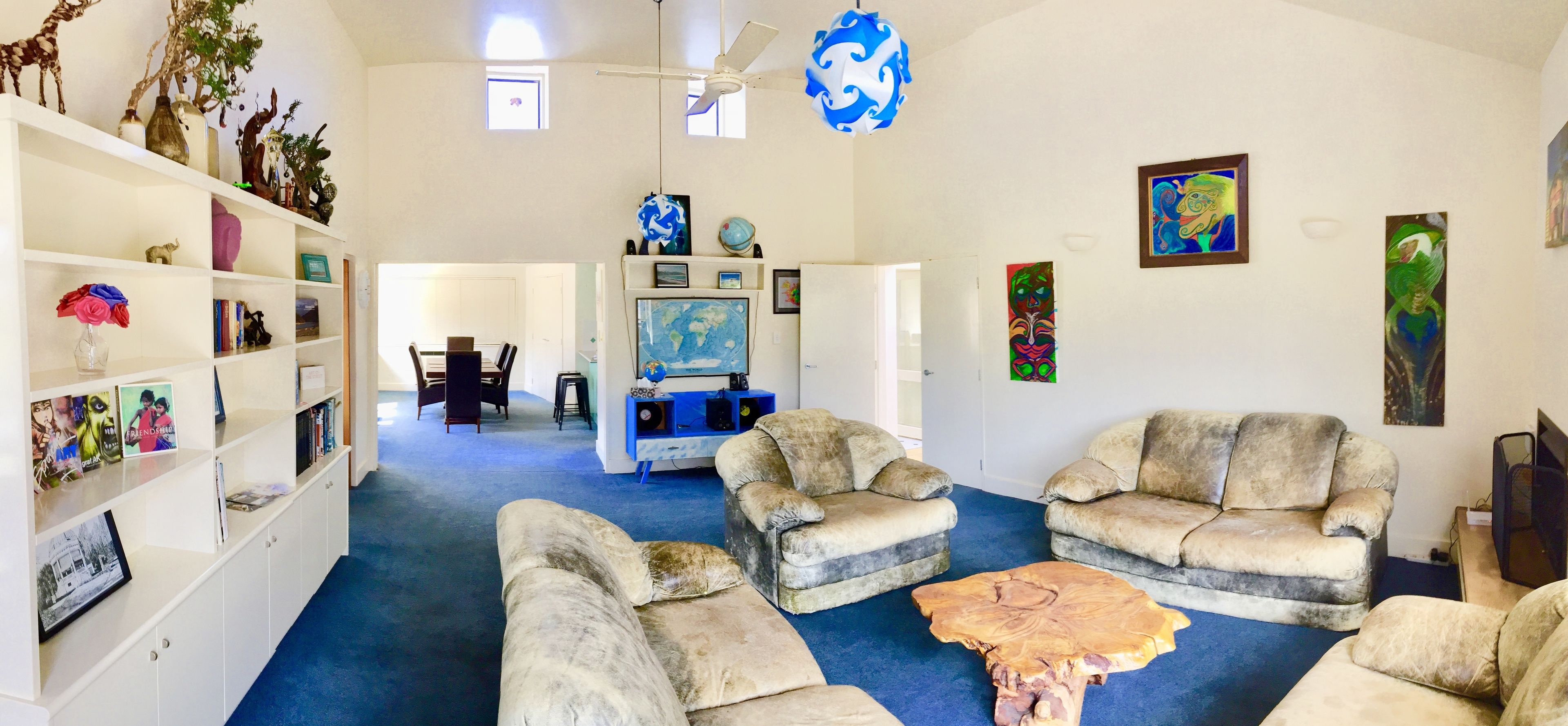 A living room with two sofas, a coffee table, a bookshelf, and a TV.