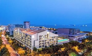 A modern hotel with multiple floors, a rooftop pool, and a view of the sea. - Joyze Hotel Xiamen Curio Collection by Hilton (Xiamen)