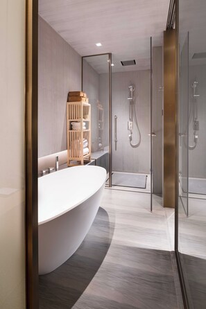A modern bathroom with a freestanding bathtub, a glass-enclosed shower, and a wooden shelf with towels. - Joyze Hotel Xiamen Curio Collection by Hilton (Xiamen)