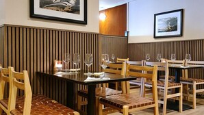 A restaurant with wooden paneling, framed artwork on the walls, and a clean, modern interior. - The Alyth Hotel (Blairgowrie)