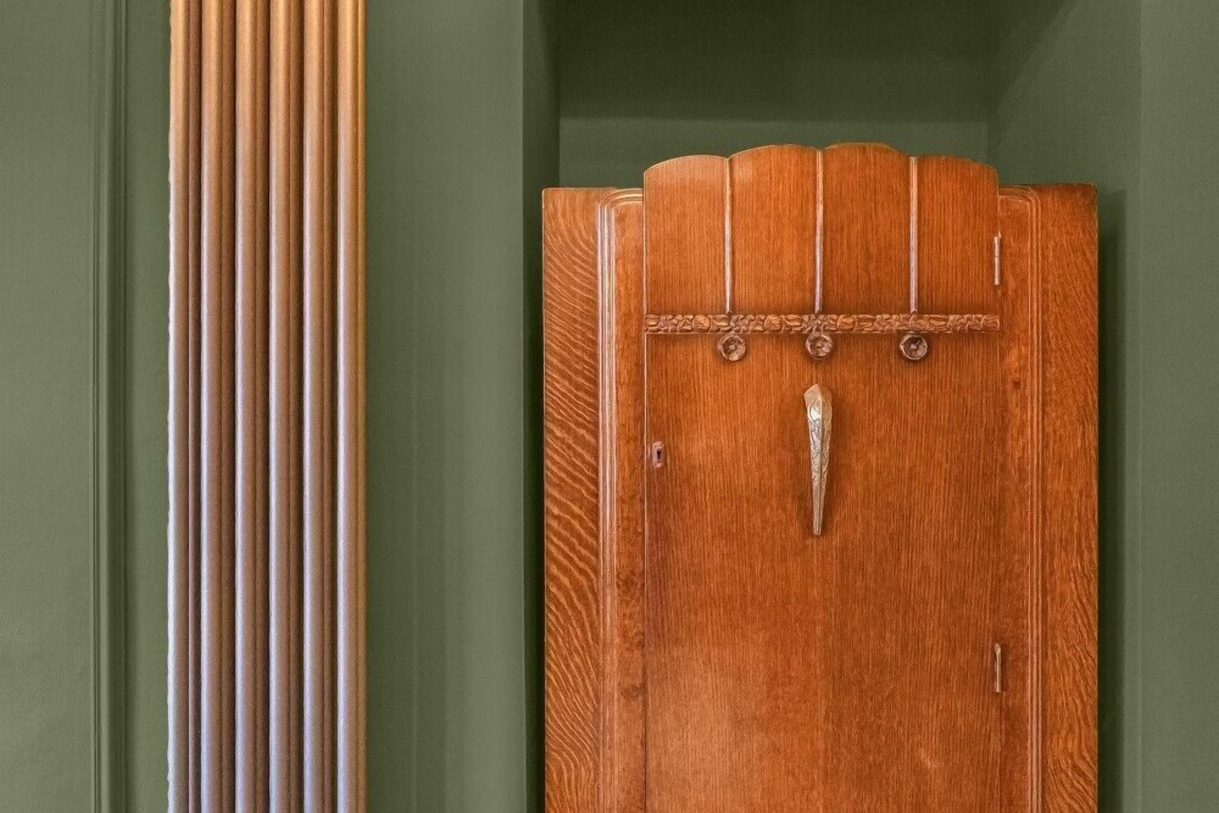 Une porte en bois, dotée d’une poignée décorative et d’un loquet en métal.