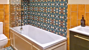 A bathroom with a bathtub, a toilet, and a sink.