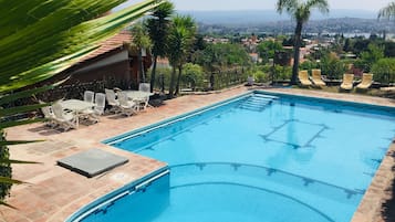 Una piscina al aire libre, sombrillas