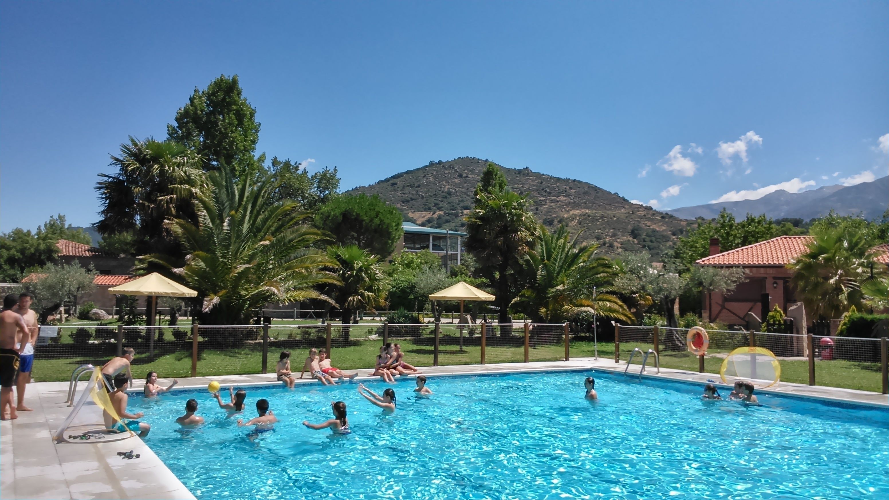 Una piscina al aire libre de temporada, sombrillas