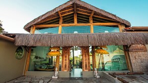A building with a thatched roof, large windows, and a sign reading "Vilakebaya". - Hotel Vila Kebaya (Ilhabela)