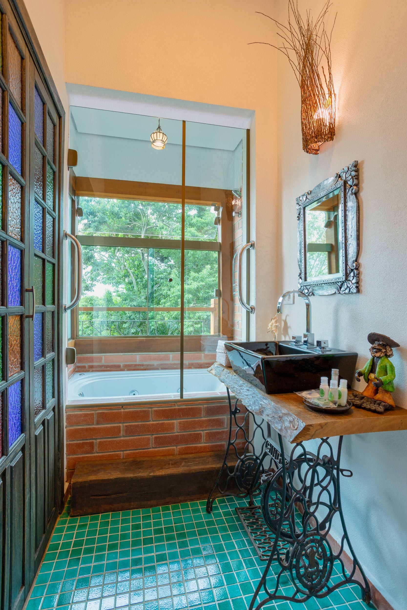 Une salle de bain avec une grande fenêtre, une baignoire, un lavabo et un miroir.