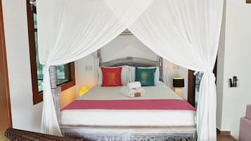 A bed with a canopy, a wooden headboard, and a decorative bench in front.