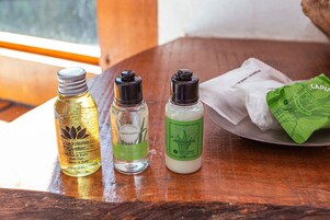 Três frascos de produtos de banho sobre uma mesa de madeira.